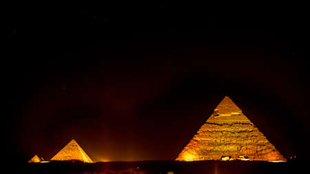 Pyramids of Giza in Egypt lit by spot lights in the evening during the light and sound showの写真素材