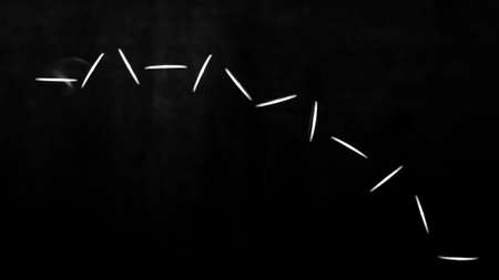 Stroboscopic effect created using flash capturing the motion of a coin as it is being tossed in the airの写真素材