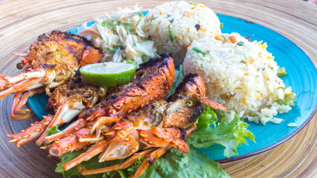 A sea food dish with grilled lobster, rice with vetetables and salad on the sideの写真素材
