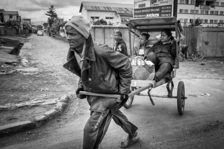 Antsirabe, Madagascar â May 24  - Malagasy people hire a Pousse-Pousse  rickshaw  for their daily commute on May 24, 2014 in Antsirabe, Madagascar のeditorial素材