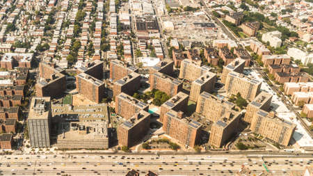 Aerial view of the Borough of Queens, New York, showing geometrically arranged and densely packed buildings and a multi-lane super highwayの写真素材