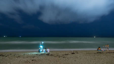 Tourists and Miami residents spend a quiet evening relaxing at the beach.のeditorial素材