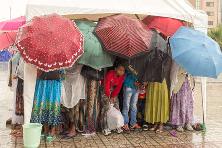Addis Ababa: April 10: Devoted Ethiopian Orthodox followers stand undeterred by the pouring rain to observe Siklet, the crucifixion of Jesus Christ, at Bole Medhane Alem Church on April 10 ,2015 in Addis Ababa, Ethiopiaのeditorial素材