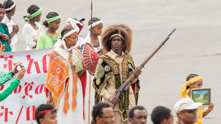 Addis Ababa  May 5: Young men and women dressed in colourful traditional outfit march flag at the 74th anniversary of Patriots' Victory day commemorating the defeat of the invading Italians on May 5 2015 in Addis Ababa Ethiopia.のeditorial素材