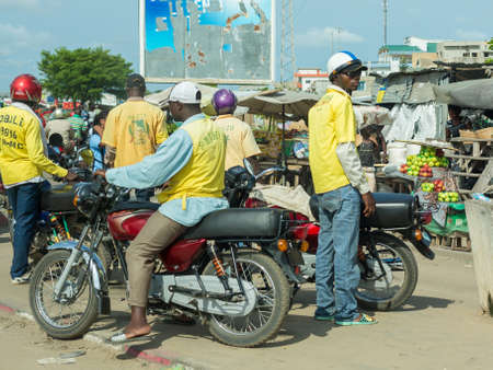 Cotonou, Benin: May 26: A man rides a Motorcycle taxi, the most common means of hired transportation in the city, on May 26, 2015 in Cotonou, Benin.のeditorial素材