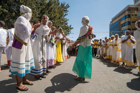 Addis Ababa - Jan 19: Young girls dressed in colorful traditional clothing sing and chant while accompanying the Tabot, a model of the arc of covenant, during a Timket procession as part of celebrations of Epiphany, on January 19, 2017 in Addis Ababa, Ethのeditorial素材