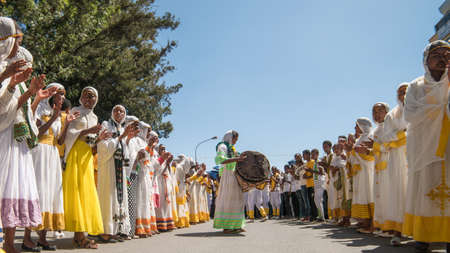 Addis Ababa - Jan 19: Young girls dressed in colorful traditional clothing sing and chant while accompanying the Tabot, a model of the arc of covenant, during a Timket procession as part of celebrations of Epiphany, on January 19, 2017 in Addis Ababa, Ethのeditorial素材