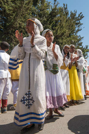 Addis Ababa - Jan 19: Young girls dressed in colorful traditional clothing sing and chant while accompanying the Tabot, a model of the arc of covenant, during a Timket procession as part of celebrations of Epiphany, on January 19, 2017 in Addis Ababa, Ethのeditorial素材