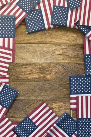 small United States flags framing a wood texture background with copy spaceの写真素材