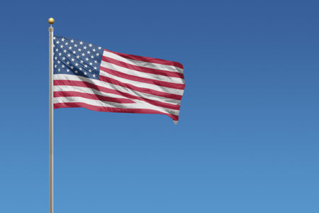 Flag of United States in front of a clear blue sky