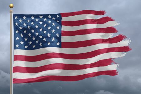 Flag of United States tattered and torn with stormy skyの写真素材