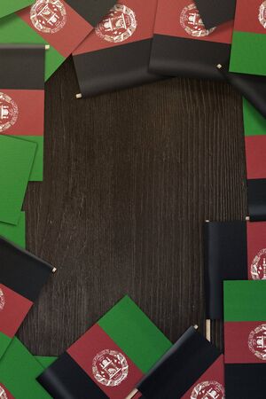 small Afghanistan flags framing a wood texture background with copy spaceの写真素材