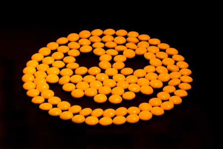 Yellow smiley emoticon made from candy, danger of drugs, drugs looking like candy conceptの写真素材