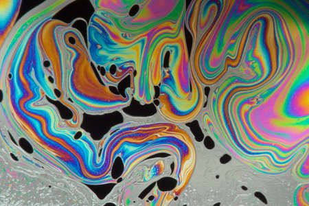 Psychedelic abstract formed by light on the surface of a soap bubbleの写真素材