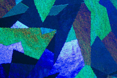 Colorful geometric patterns formed by light reflecting off a textured metallic surfaceの写真素材