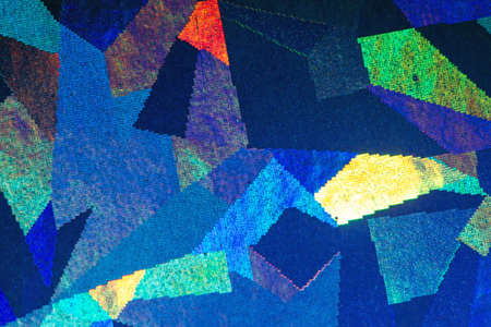 Colorful geometric patterns formed by light reflecting off a textured metallic surfaceの写真素材
