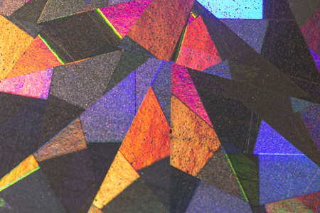Colorful geometric patterns formed by light reflecting off a textured metallic surfaceの写真素材