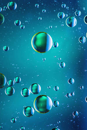 Psychedelic oil and water abstract background formed by oil droplets floating on waterの写真素材