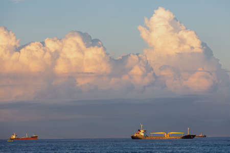 Ships on the background of the sky with big white clouds at sunset.の写真素材
