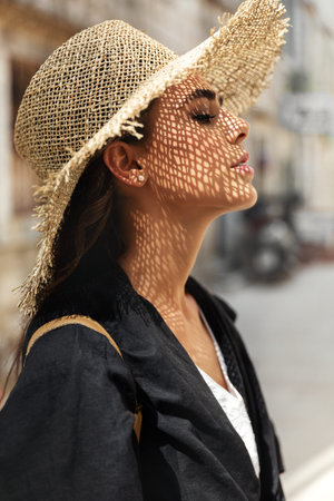 Profile portrait of a beautiful girl in a straw hat.
