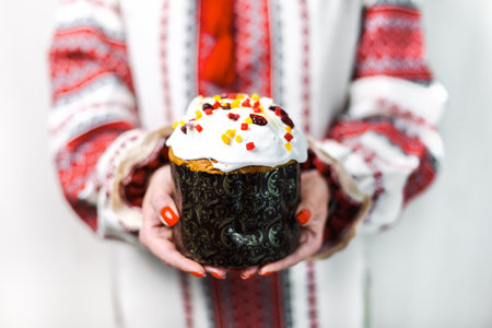 A girl in an embroidered dress holds an Easter cake in her hands. Easter holiday. Ukrainian...