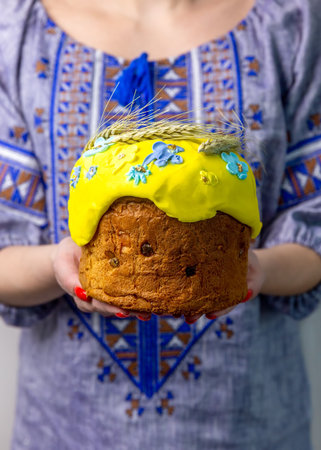 A girl in an embroidered dress holds an Easter cake in her hands. Easter holiday. Ukrainian traditions.Easter cardの写真素材