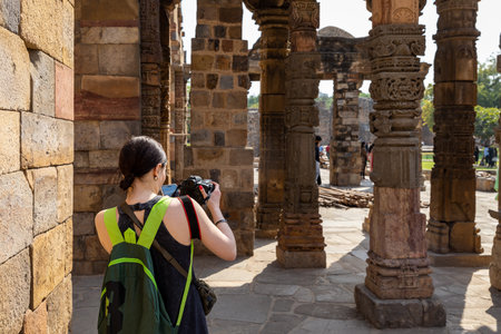 A woman takes a photo of an ancient building in Indiaの写真素材