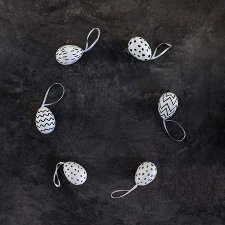 Easter eggs with a black and white pattern on a black backgroundの写真素材