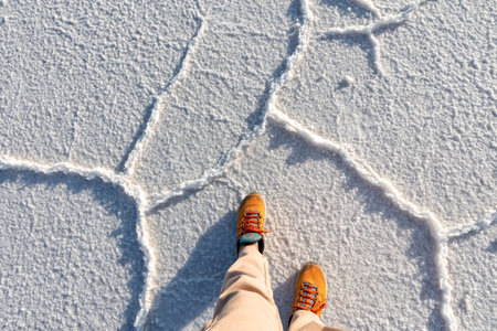 Salar de Uyuni, Bolivia. The tourist's feet stand on the salt surface.の写真素材