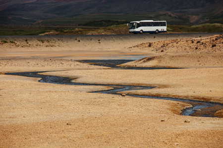 A winding river next to the road along which the bus travels. Icelandの写真素材