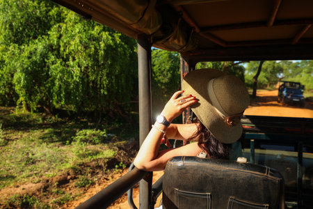 A tourist in a hat sits in a car and looks at nature. Safariの写真素材