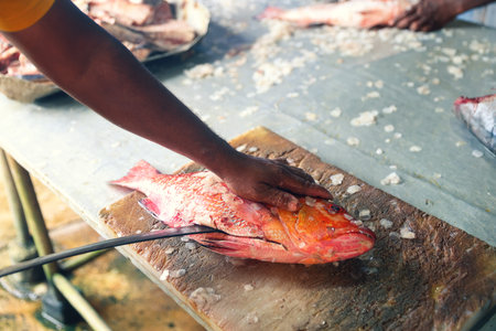Man cutting fish with a knife at a local Asian market