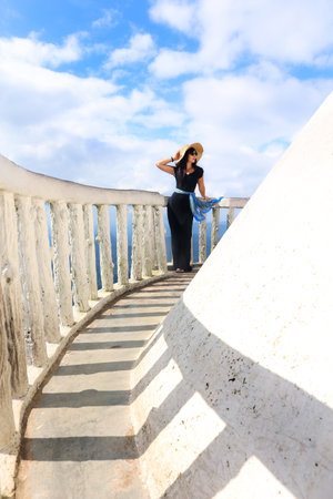 Tourist in black long dress and hat at Ambuluwa Tower in Sri Lanka. Interesting and popular places in Sri Lankaの写真素材