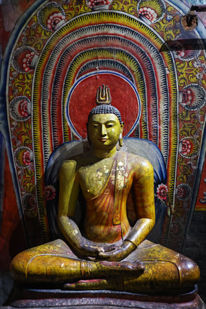 Buddha statue and fresco in the Buddhist cave temple in Dambulla, Sri Lankaの写真素材