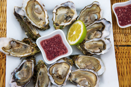 Fresh oysters on a plate with lemon and sauce