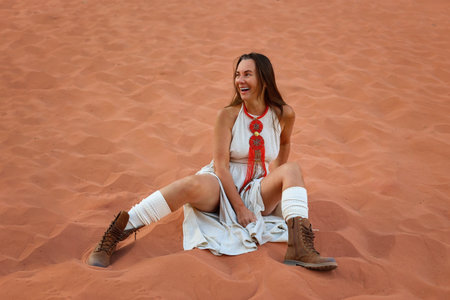Adventurous Woman Relaxing on Red Sand Dunesの素材