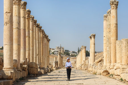 Woman walking through the grand Roman ruins of Jerash, Jordanの写真素材