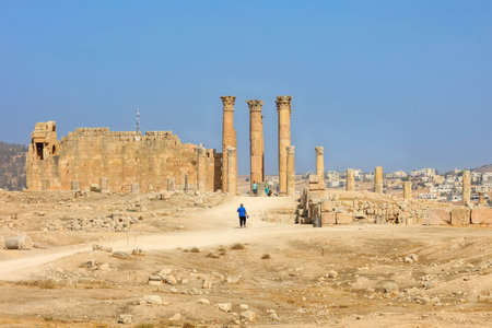 Ancient Roman Ruins with Towering Columns in a Desert Landscapeの写真素材