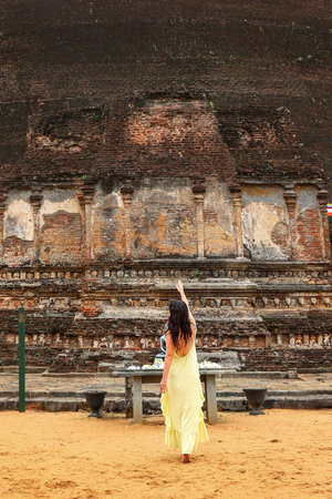 Woman in yellow dress exploring ancient brick ruinsの写真素材