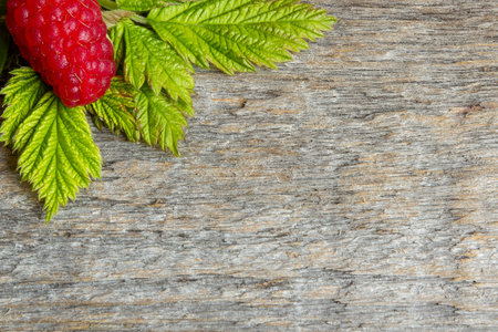 Red raspberries and place for text. Wooden background.