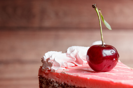 Chocolate cake with cherries on wooden background.の写真素材
