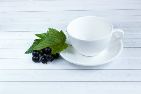 Empty Cup and black currants on wooden background.の写真素材