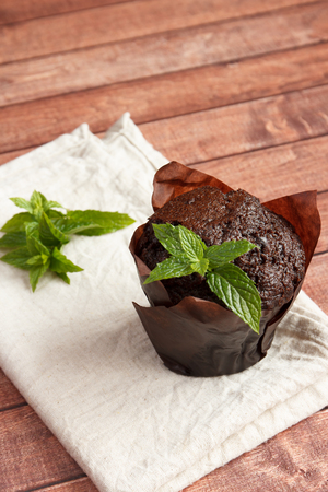 Chocolate cupcakes with mint on wooden tableの写真素材