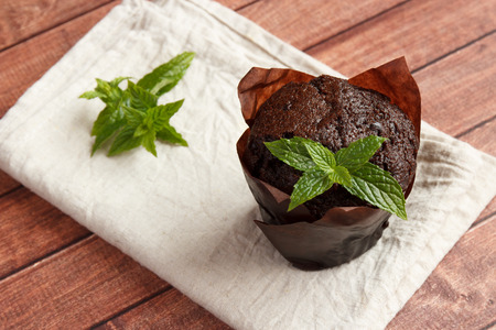 Chocolate cupcakes with mint on wooden tableの写真素材