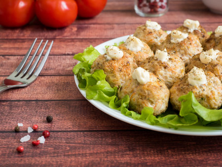 Delicious meatballs with parsley, lettuce and tomato closeup on a plate on the table. horizontal.