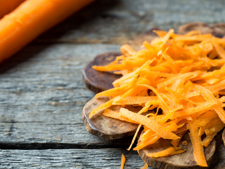 Grated carrots on a wooden rustic background Copy space.の写真素材