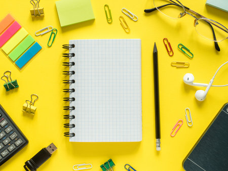 Business flat lay with copy space, calculator, pencil, Notepad, coffee glasses on colorful yellow...