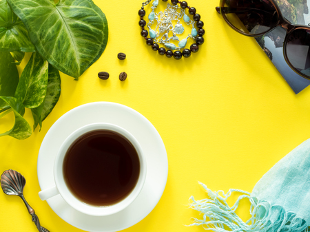 Vacation concept, summer Green leaves plant coffee Cup sunglasses bracelet hat clothes coffee on yellow background, flat lay, copy spaceの写真素材