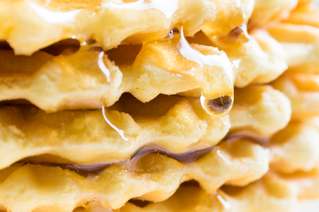 Background of waffles, Patterned cookies, sprinkled with honey and raspberries. Selective focusの写真素材