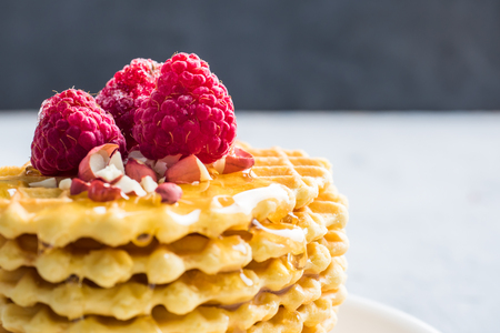 Wafers, Patterned biscuits drizzled with honey with raspberry and peanut on a grey background black wall.の写真素材